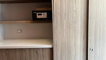 A room with a built-in wooden cabinet with drawers and shelves, a control panel, and a sliding door.