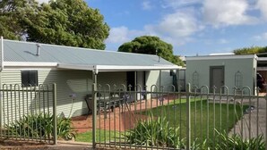 A single-story house with a covered patio, a fenced yard, and a small garden. - Sea Salt Apartment 3 - Short walk to beach! Free WiFi! newly decorated! (Stansbury)