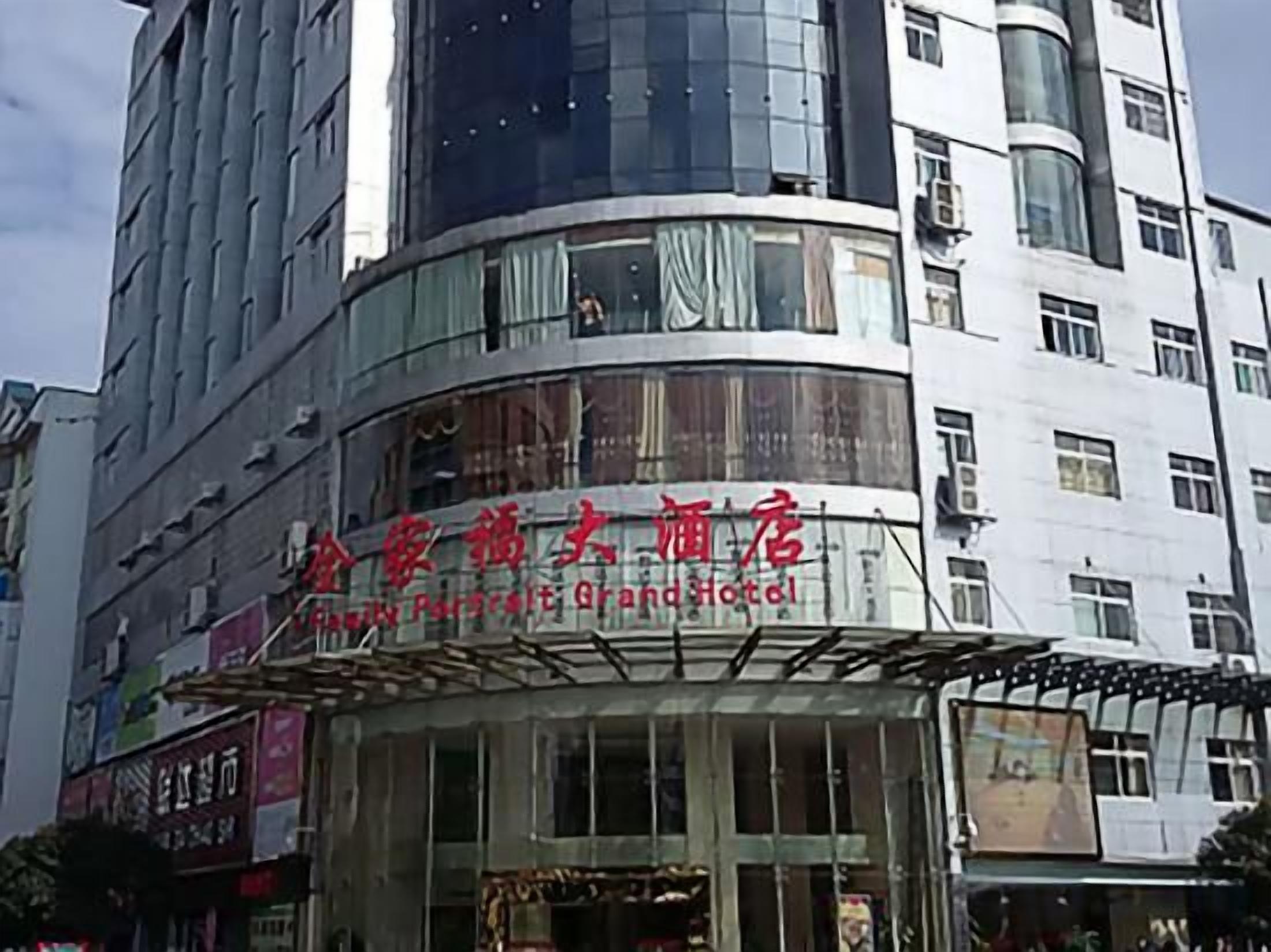 Un hotel con fachada curva, ventanas amplias y señalización en un idioma extranjero.