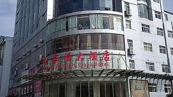 Un hotel con fachada curva, ventanas amplias y señalización en un idioma extranjero.