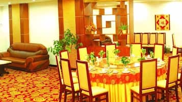 A dining area with a round table, chairs, and a red carpeted floor.