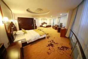 Une chambre d’hôtel avec un grand lit, un bureau, une chaise et un téléviseur.