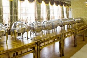 A buffet setup with multiple serving stations and a long wooden table. - Family Portrait Grand Hotel (Guidong)