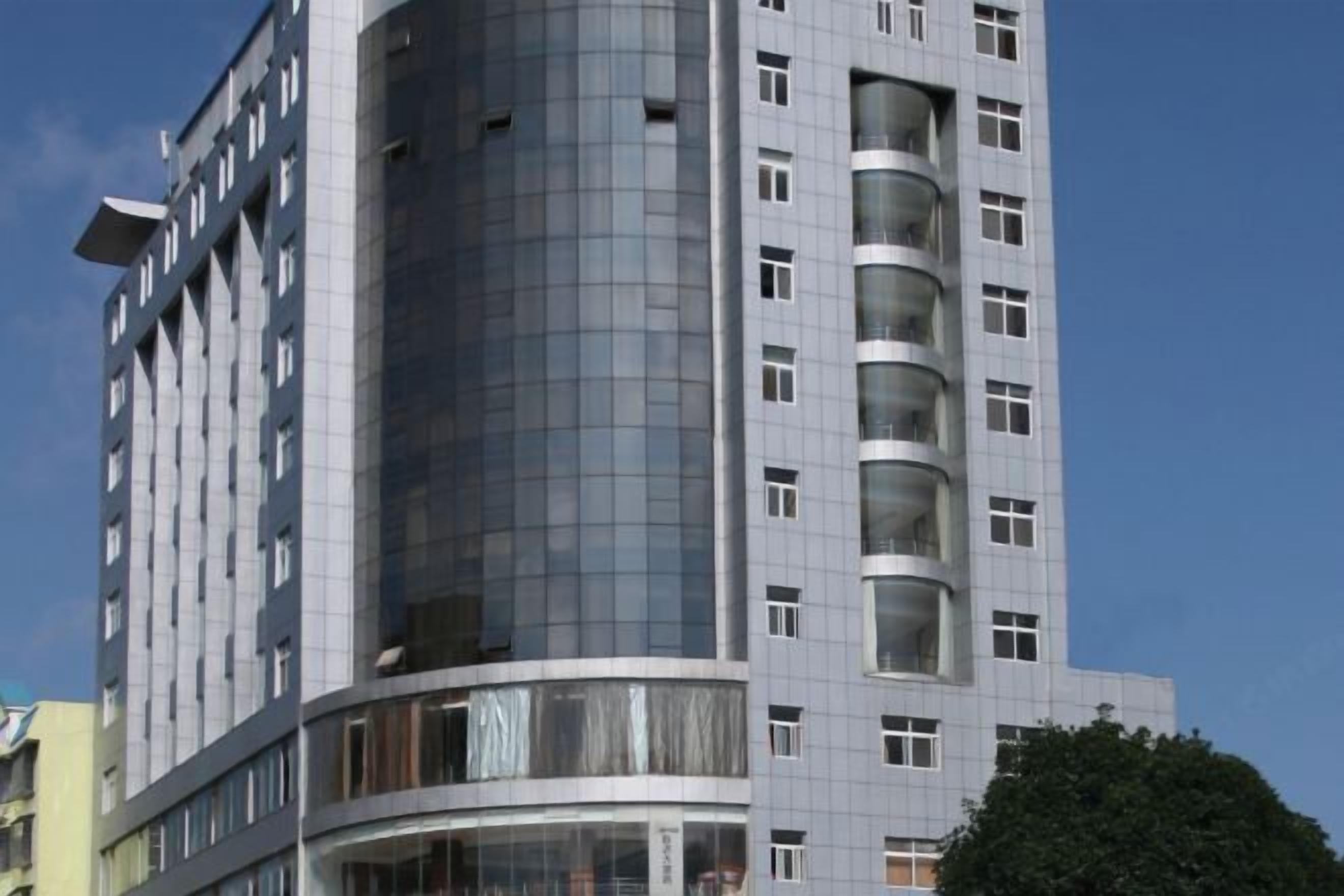 Un edificio moderno de gran altura con varios balcones y ventanas amplias.