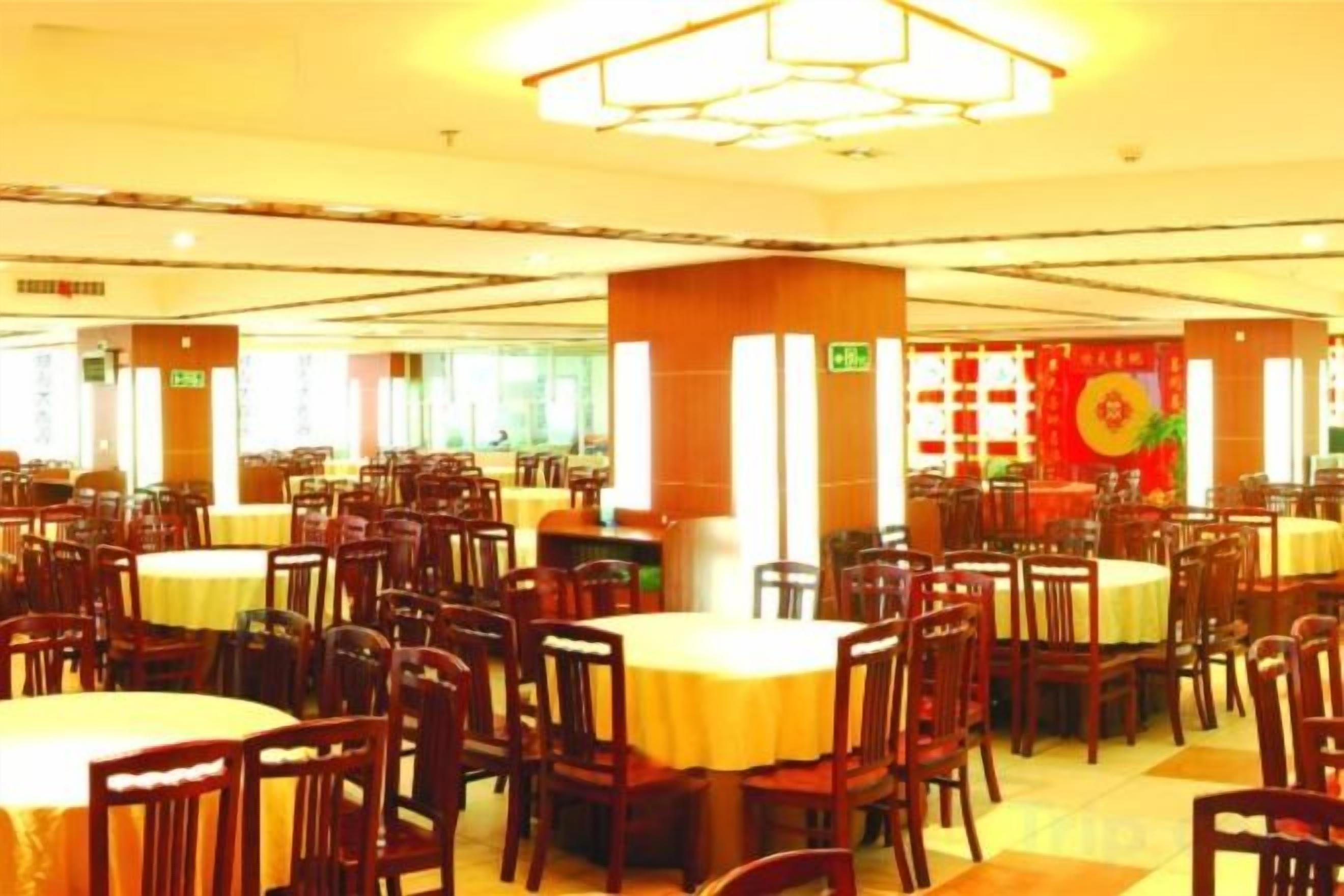 Un comedor con varias mesas y sillas, dispuestas en filas.