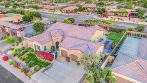 Un barrio residencial con casas de fachadas de piedra, tejados de tejas rojas y jardines bien cuidados.