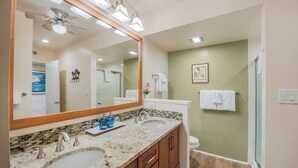 A bathroom with two sinks, a large mirror, and a ceiling fan. - Lea Casa at Casa de Emdeko (Kailua-Kona)