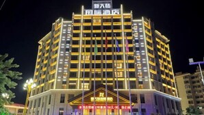 A multi-story hotel with a prominent entrance and illuminated signage. - Xindalu International Hotel (Yuanjiang)