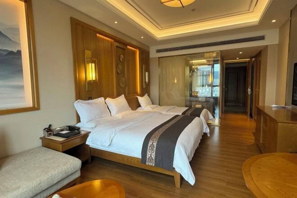 Una habitación de hotel con una cama grande, un escritorio, una silla y un televisor.