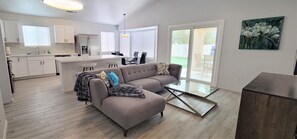 Relax in this stylish living area with a sofa, coffee table, and dining space.