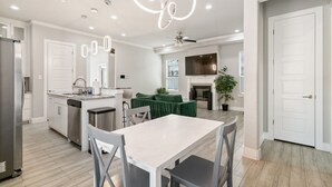 Une cuisine moderne dotée d’un îlot central, de meubles blancs et d’appareils électroménagers en acier inoxydable.