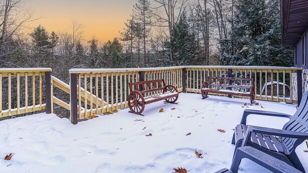 A snow-covered deck with wooden benches and chairs, surrounded by trees. - Scenic Deep Creek Getaway Cabin-RICK'S RETREAT (Oakland)