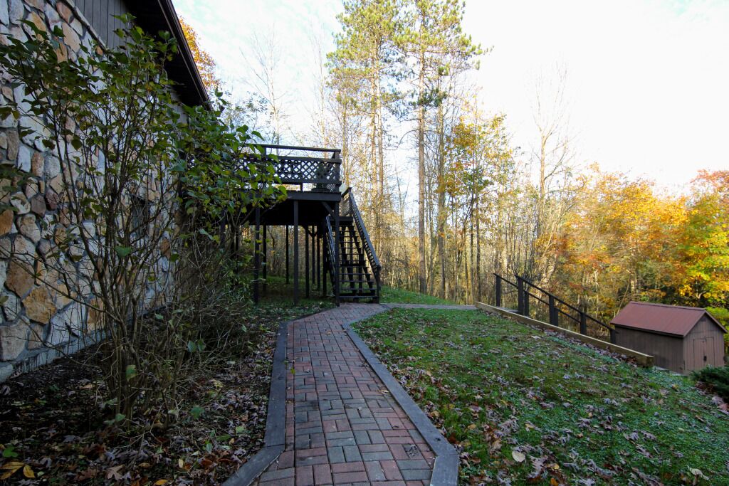 A stone building with a brick pathway leading to a wooden deck.