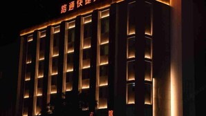 Un edificio con líneas verticales iluminadas y un cartel en un idioma extranjero.