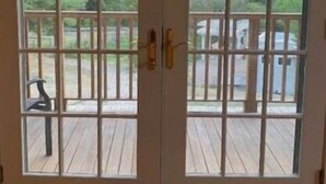 A set of double doors with a view of a wooden deck and a body of water. - Farm Stay with Horses & Pool with Mountaintop Views (Bloomfield)