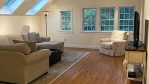 A spacious living room with a sofa, armchair, and a television on a stand. - Farm Stay with Horses & Pool with Mountaintop Views (Bloomfield)