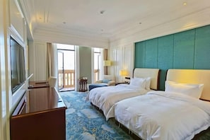 A hotel room with two beds, a TV, a desk, and a balcony. - Feilong Hotel (Xiangyun)