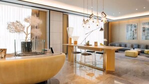 Una sala de estar moderna con un mostrador de recepción curvo, un sofá y un comedor con taburetes de bar.