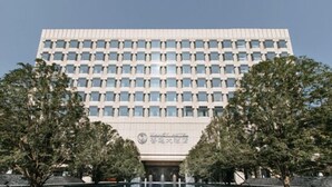 Un edificio moderno con fachada simétrica, ventanas amplias y una entrada central.