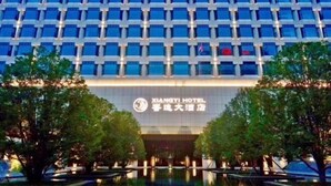 Un edificio de hotel con una cuadrícula de ventanas y un letrero que dice 'Xiangyi Hotel'.