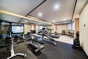 A modern gym with cardio equipment, weight machines, and a mirrored wall. - BBH Hotel (Xinchang Ocean City) (Xinchang)