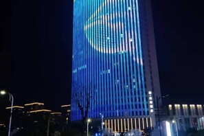 A tall building with vertical lines and a circular design at the top. - BBH Hotel (Xinchang Ocean City) (Xinchang)