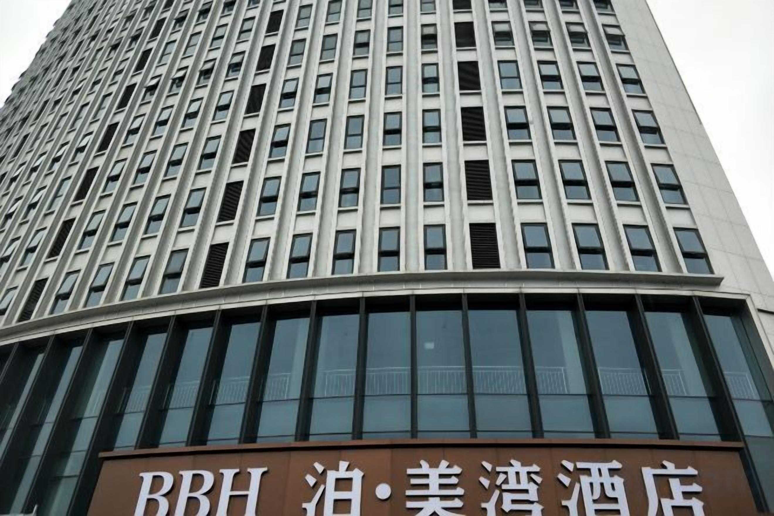 Un grand immeuble sur lequel on peut lire l’inscription « BBH Hotel ».