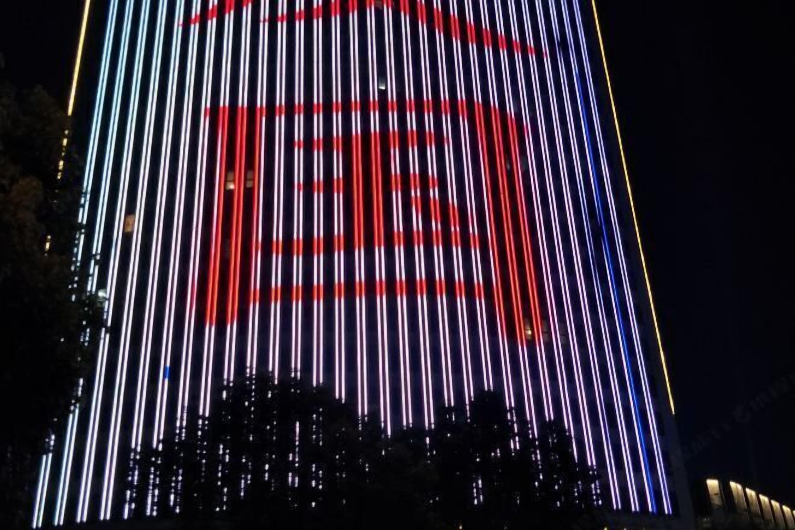 A building facade with vertical light strips in red, white, and blue.