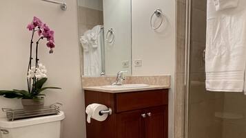 Een bad/douchecombinatie, een bubbelbad, een haardroger, handdoeken