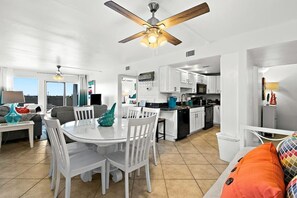 Enjoy meals around the round dining table with comfortable white chairs.