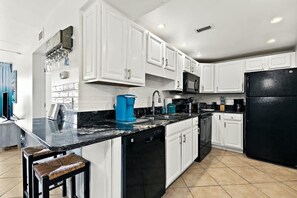 Enjoy cooking in this fully equipped kitchen with a coffee maker, dish rack, and bar stools.