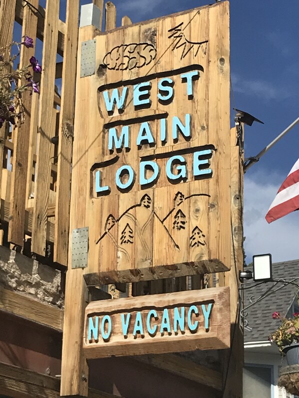 Ein Holzschild für die West Main Lodge mit der Aufschrift 'Keine Zimmer frei'.
