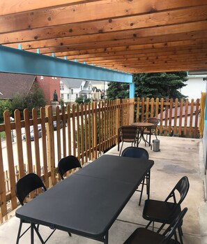 Eine Terrasse im Freien mit Holzzaun, Tisch und Stühlen.