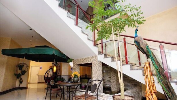 A spacious indoor area with a dining table, chairs, and a staircase. - Changchun Jinsha Hotel (Changchun)