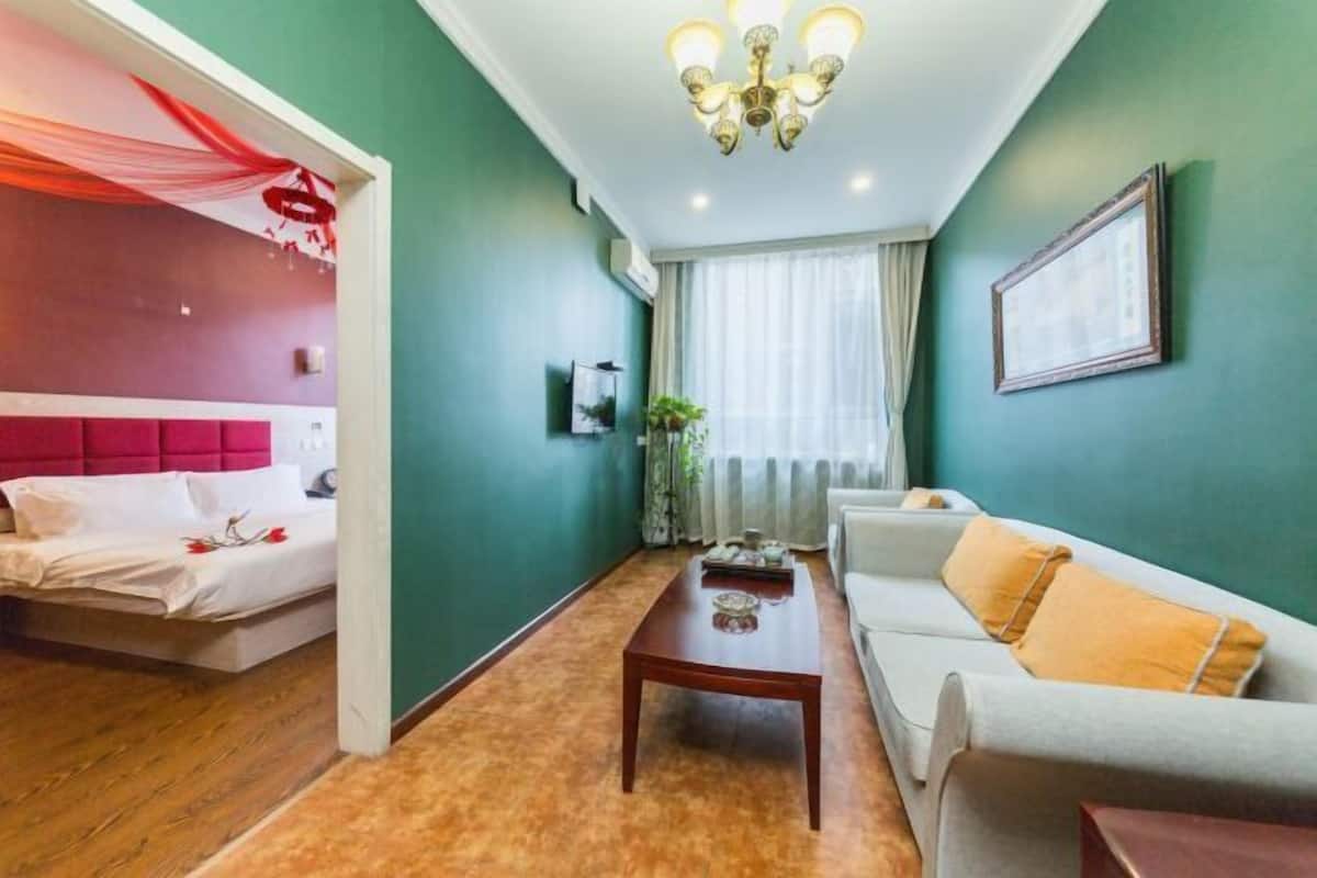 Ein Hotelzimmer mit Bett, einer Couch, einem Couchtisch und einer Chandelier.