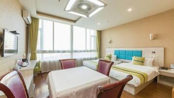 A hotel room with a bed, a desk, and a chair.
