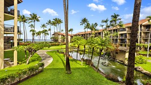 Un resort con piscina, palmeras y vista al océano.