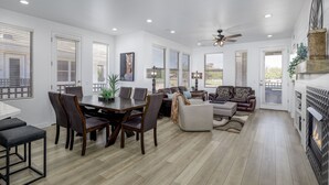 A spacious living area with a dining table, sofas, and a fireplace.