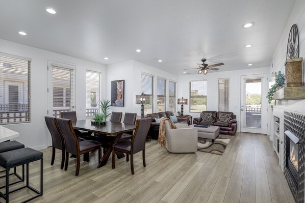 A spacious living area with a dining table, sofas, and a fireplace.