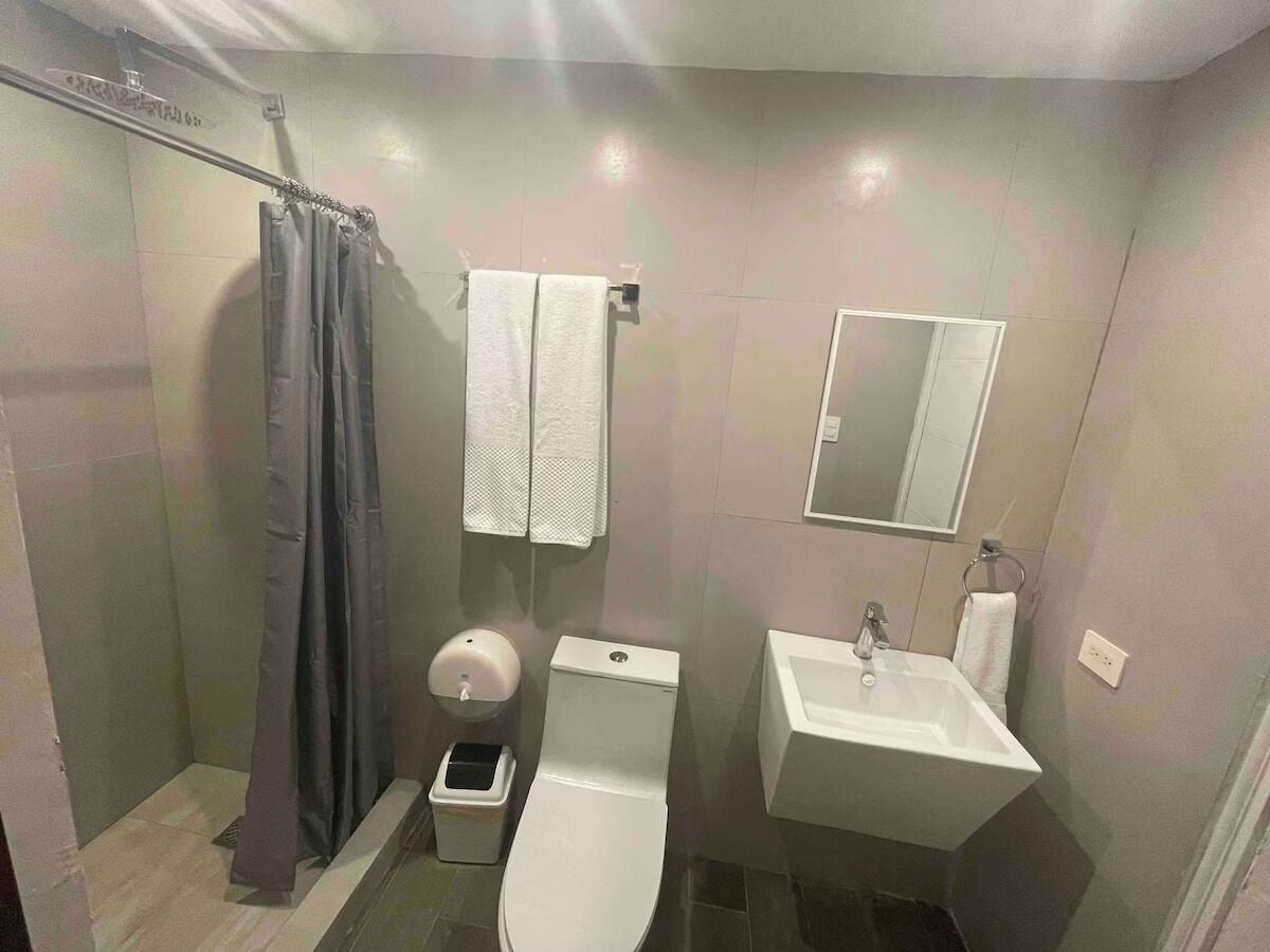 A compact bathroom with a shower, toilet, and sink.