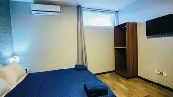 Une chambre d’hôtel équipée d’un lit, d’une armoire, d’une télévision et d’un appareil de climatisation.