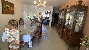 A dining area with a long table, chairs, a chandelier, and a cabinet with glass doors. - 300MB/S Wifi with an amazing pool 3 Bed 2.5bath house (Mérida)