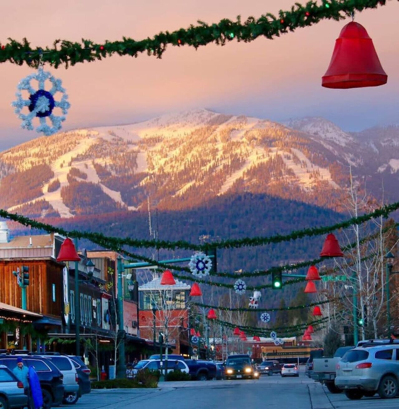 Une rue bordée d’immeubles, avec une montagne en arrière-plan.