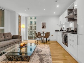A modern apartment with a living area, dining space, and kitchen.