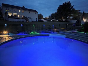 Una piscina con borde curvo, rodeada por una valla de metal negro.