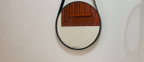 A bathroom with a white sink, a mirror with a wooden frame, and a towel hanging on a hook.