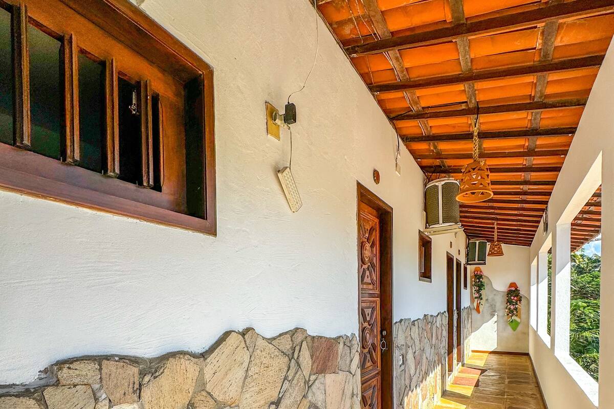 A corridor with stone walls, wooden doors, and a tiled floor.