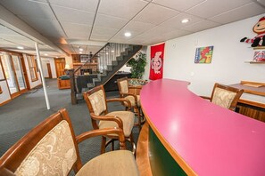 A hotel lobby with a reception desk, seating area, staircase, and a red wall with a football-themed poster.