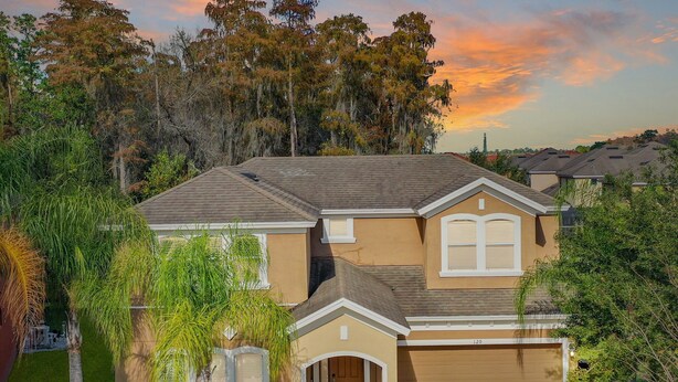 A two-story house with a front entrance, a garage, and a well-maintained lawn.