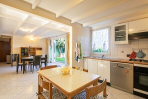 Una cocina con una mesa de comedor, sillas, lavavajillas y estufa.